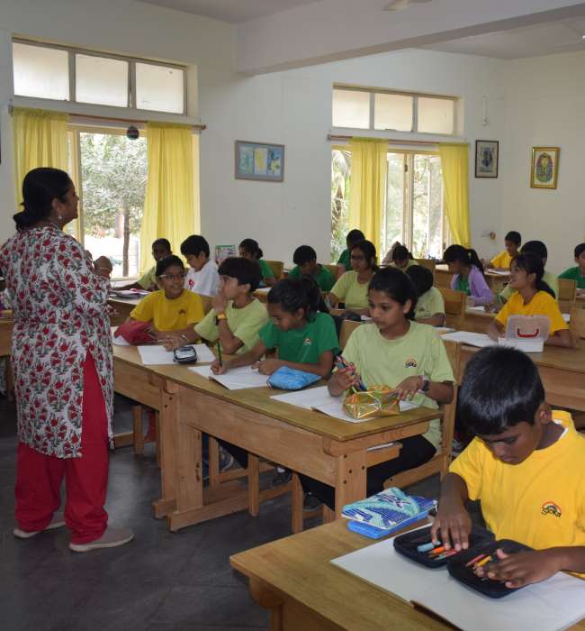 A teacher addressing students in a classroom during a lesson.