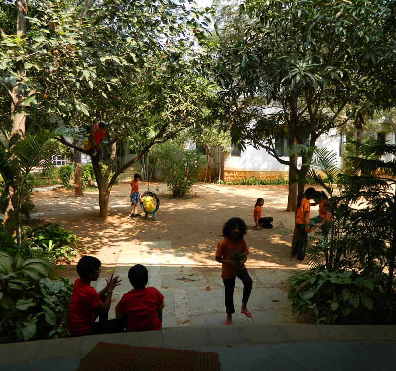 Students of Sloka as seen from the school building, occupying various points of the school’s courtyard.