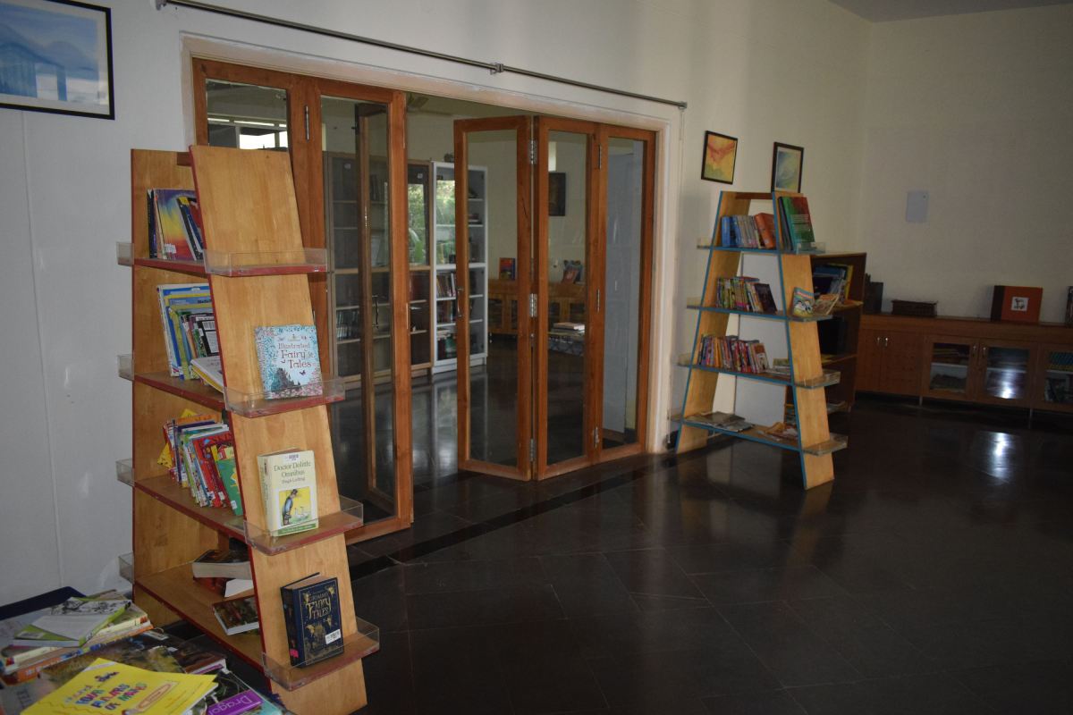 A library entrance with shelves containing books on either side of the doors.